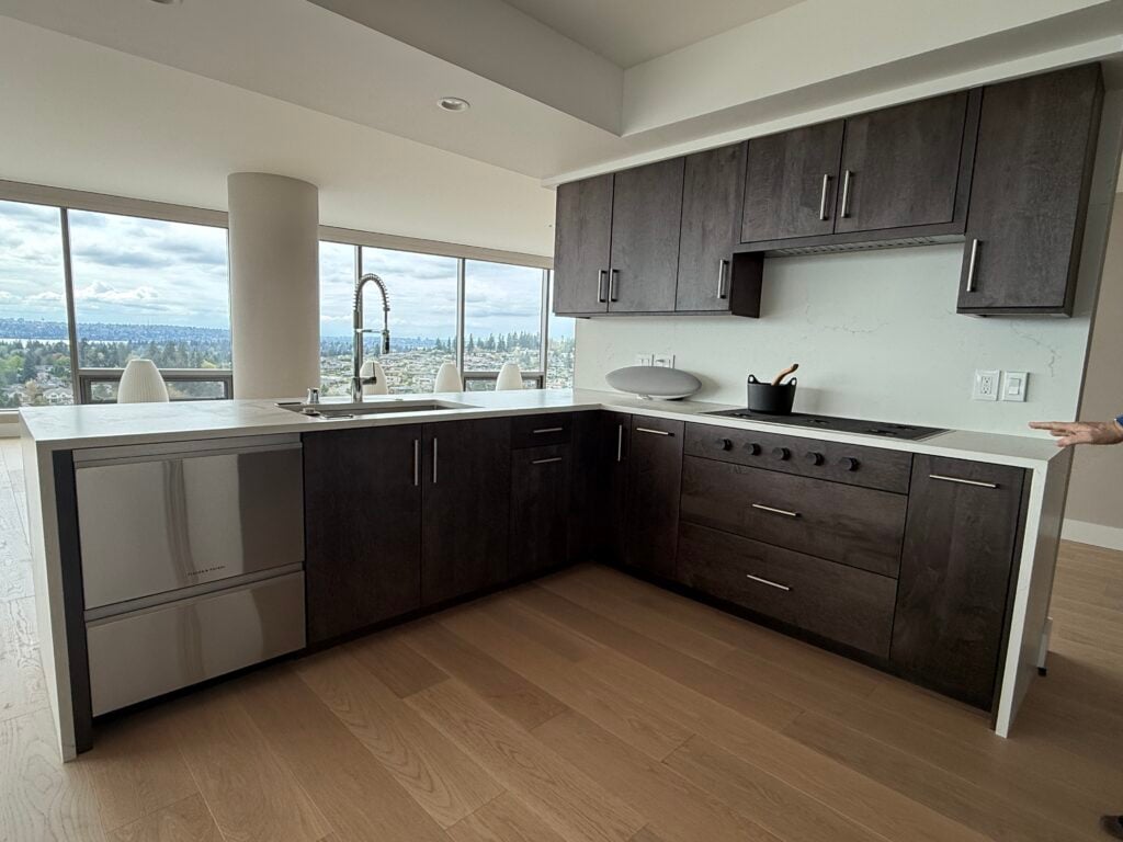 Dark wood custom kitchen cabinets with quartz waterfall island in a Bellevue condo