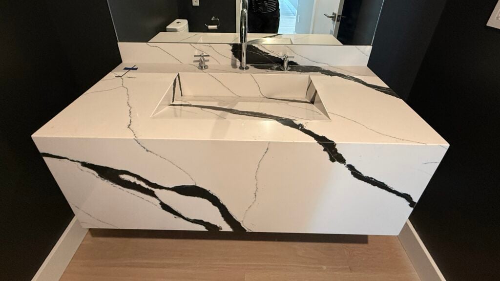 Bold-veined white slab waterfall vanity with integrated sink