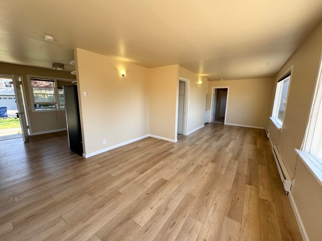 Wide-plank light oak flooring through an open living area